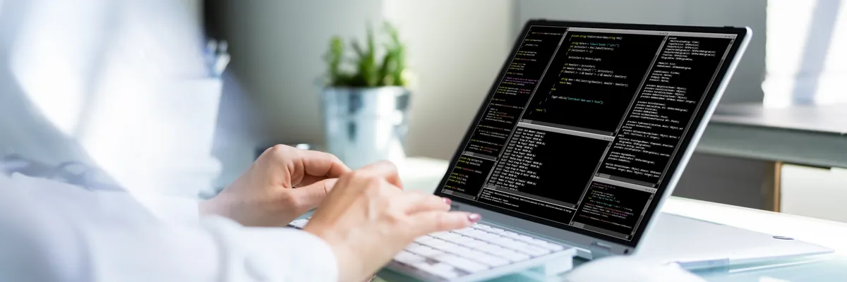 Entwicklungsarbeit am Laptop mit Quellcode auf dem Bildschirm